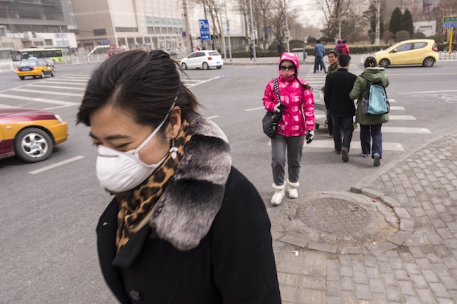 BRAVING POLLUTION. This file photo taken last year shows local residents braving dust storms combined with hazardously high air pollution in Beijing, China. Photo by Adrian Bradshaw/EPA
