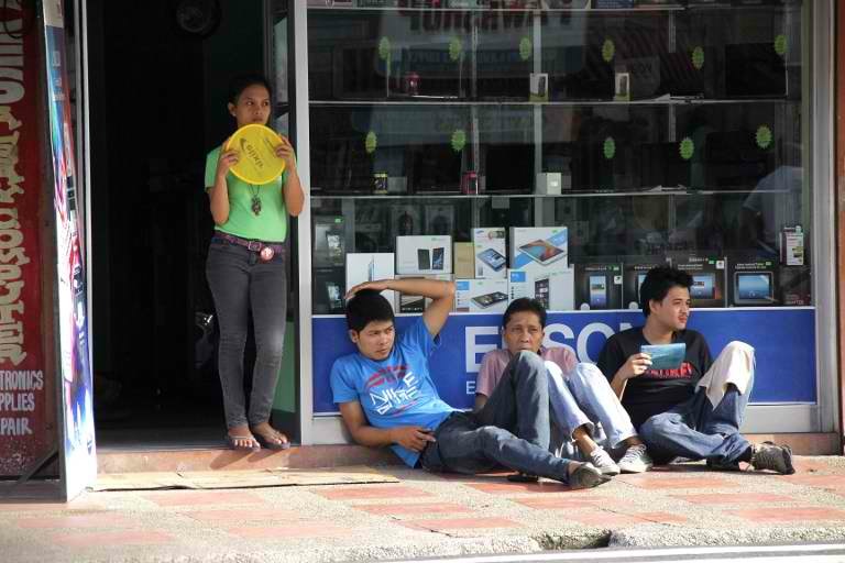 ENDURING THE BLACKOUT. Employees of an electronics shop rest outside their shop in Legazpi City, Albay province, southeast of Manila on July 31, 2013, after a power provider cut electricity to an entire province over unpaid debts dating back 15 years. Photo by AFP/Charism Sayat
