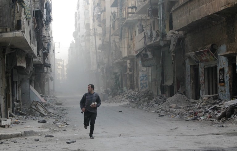 RUNNING FROM DANGER.  A rebel fighter from the Free Syrian Army runs in a street of Aleppo's Salah al-Din neighborhood during fighting against Syrian government forces on November 18, 2013. AFP / Karam al-Masri
