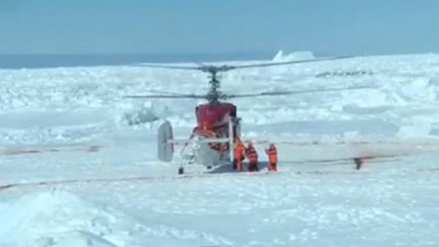 AWAITED RESCUE. Chinese icebreaker Xue Long touches down on a landing pad of a Russian research ship to rescue stranded passengers. Screenshot from a video by expedition leader Chris Turney  