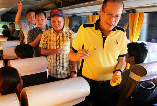 PRESIDENTIAL GIVEAWAYS. Aquino distributes baller bands to passengers while inspecting the Victory Liner Bus Terminal in EDSA, Pasay City. Photo by Gil Nartea / Malacañang Photo Bureau.