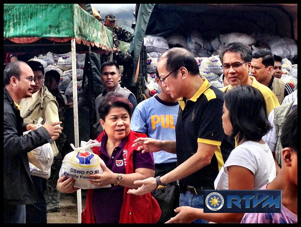 RELIEF OPERATIONS. President Aquino hands out relief goods with Social Welfare Secretary Dinky Soliman in Compostela Valley. Photo from RTVM 
