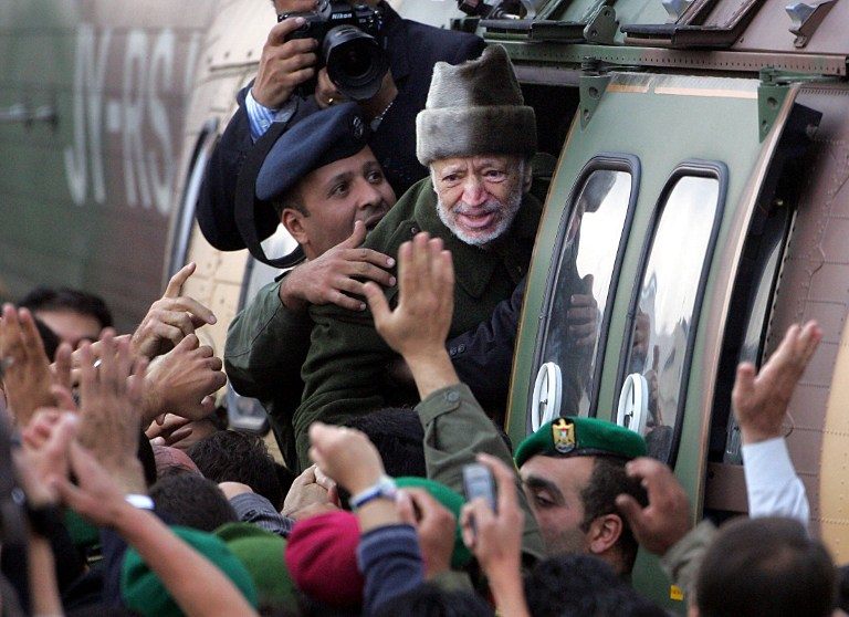 POISONED? A file picture taken on October 29, 2004, shows ailing Palestinian leader Yasser Arafat saying goodbye to well-wishers as he boards a Jordanian army helicopter at dawn at the Muqatta, his West Bank offices in Ramallah. AFP PHOTO/ODD ANDERSEN