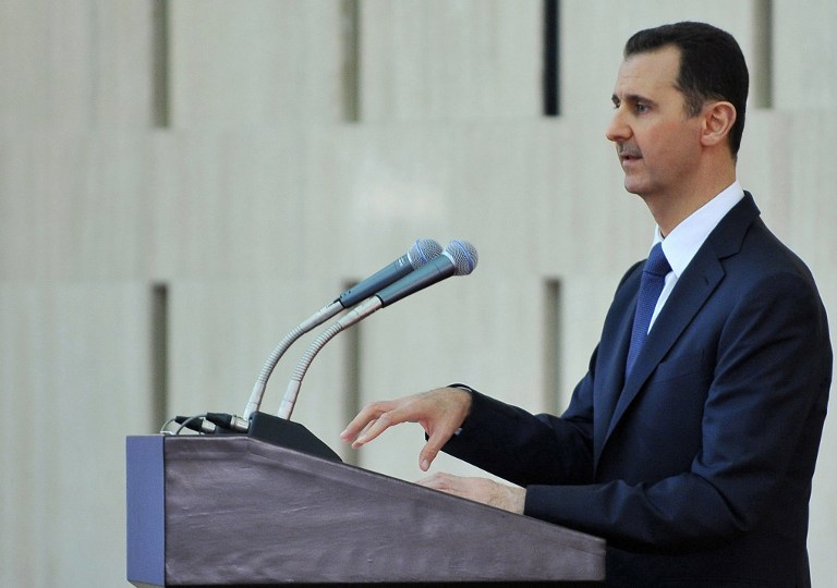 A handout picture released by the Syrian Arab News Agency (SANA) shows President Bashar al-Assad giving a speech at an "iftar" meal on the last week of the Muslim holy month of Ramadan with political and religious figures in Damascus on August 4, 2013. Photo by AFP/SANA handout