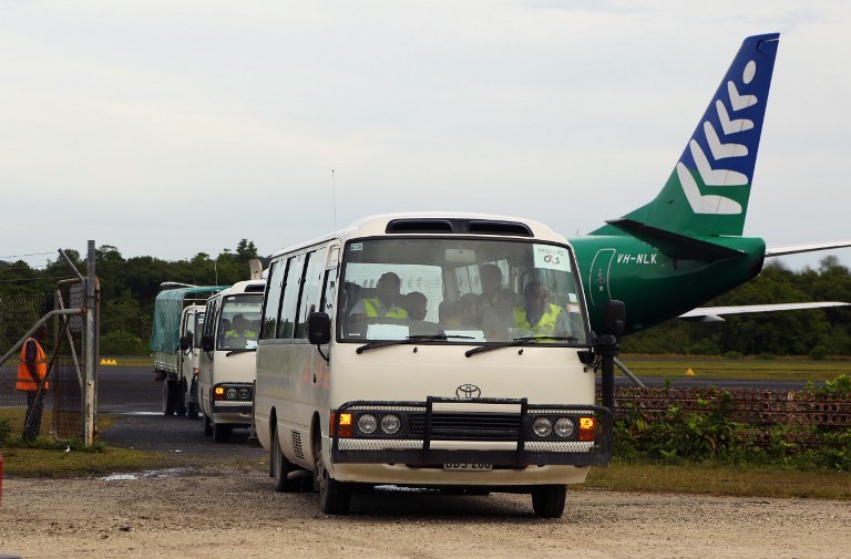NEW REFUGEE POLICY. This Australian government handout photo taken on August 1, 2013 shows the first group of 40 asylum-seekers arriving in mini-buses shortly after landing on Manus Island, Papua New Guinea (PNG), formally bringing into effect the Regional Settlement Arrangement. Photo by AFP / Australian Department of Immigration and Citizenship Handout