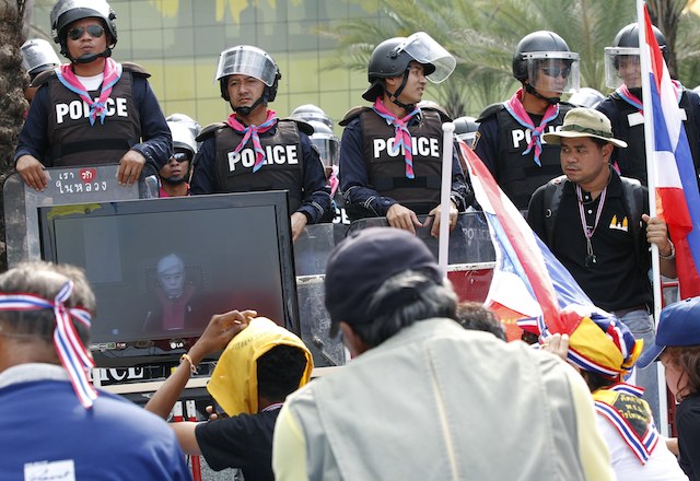 COURT RULING. Thai anti-government protesters listen as the Constitution Court judge seen on a television screen (L), reads the verdict at the Constitutional Court in Bangkok, Thailand, 20 November 2013. EPA/Narong Sangnak