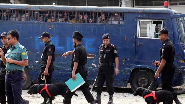 VERDICT. Policemen patrol as Bangladeshi people accused in the 2009 Peelkhana murder case look through the window of a bus. Photo by EPA/ABIR ABDULLAH