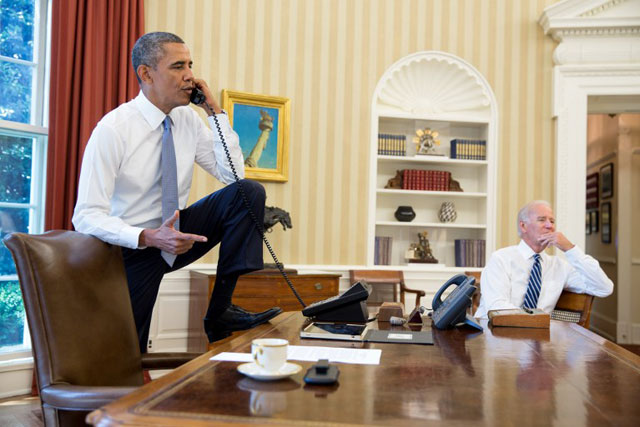 US President Barack Obama talks on the phone with US House of Representatives Speaker John Boehner, as Vice President Joe Biden listens. Obama seeks Congress approval to authorize military action against Syria. Photo by AFP/The White House/Pete Souza