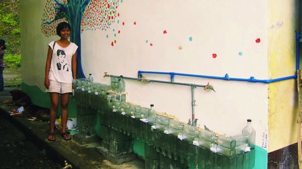 WASHING AREA PROJECT. Bianca with the local school's washing area, created out of gin bottles. Photo from Bianca Silva