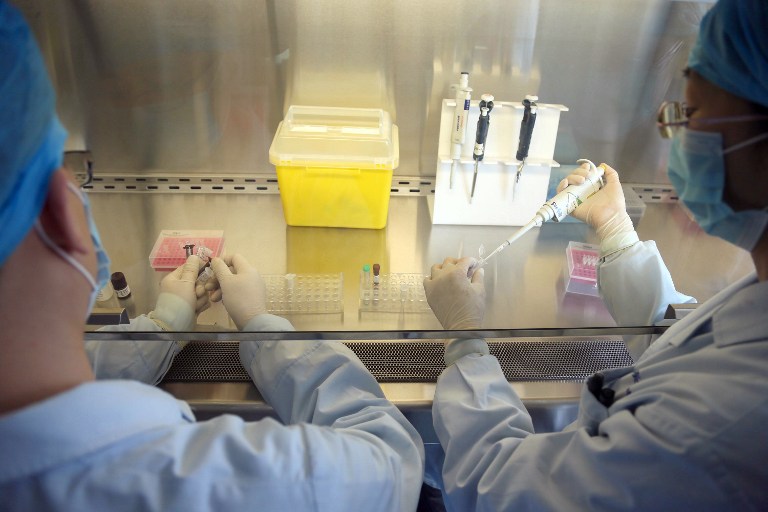 FLU TESTING. This picture taken on April 3, 2013 shows Chinese health workers preparing an H7N9 virus detection kit at the Center for Disease Control (CDC) in Beijing. AFP PHOTO