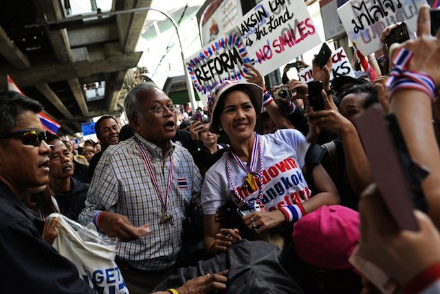 LEADING THE PROTESTS. Thai protest leader Suthep Thaugsuban poses for a picture with a supporter as anti-government protesters march through downtown Bangkok on January 15, 2014. Christophe Archambault/AFP