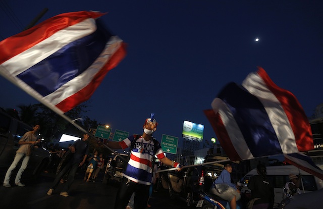WAVING THE FLAG. A Thai anti-government protester waves national flags during a mass rally blocking a main road in Bangkok, Thailand, 12 January 2014. Narong Sangnak/EPA