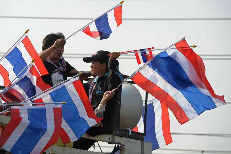 BACK IN THE STREETS. Thai anti government protesters wave national flags as they rally during a demonstration at Government Complex in Bangkok on December 9, 2013. AFP / Pornchai Kittiwongsakul
