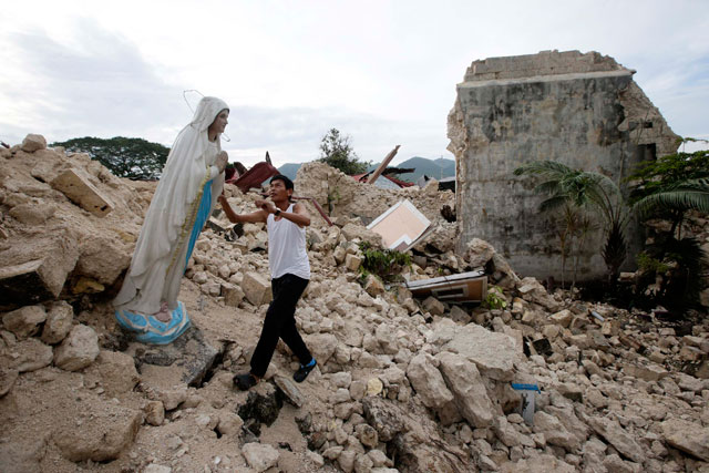 AFTERMATH. A local examines the statue of Mary amidst the rubble of a damaged church destroyed by the 7.2-magnitude earthquake in the town of Maribojoc in Bohol. Photo by EPA/Dennis Sabangan