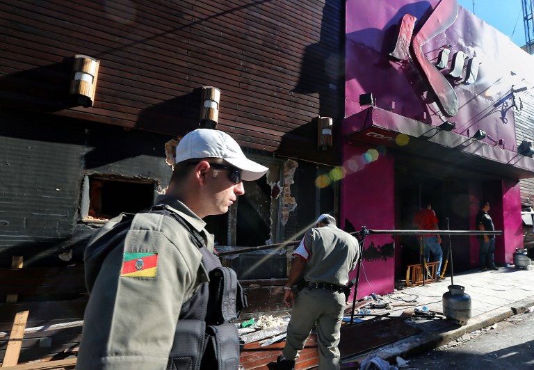 Policemen check the Kiss nightclub where a blaze on the eve killed more than 230 people, on January 28, 2013 in Santa Maria, southern Brazil. AFP PHOTO / JEFFERSON BERNARDES