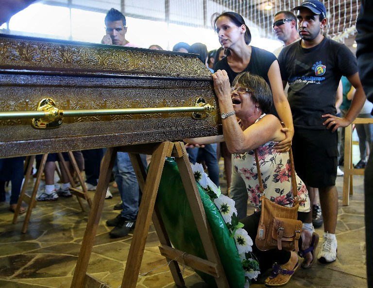 IN MOURNING. Relatives of victims from a fire that broke out at a nightclub weep, during their funeral in Santa Maria, 550 km from Porto Alegre, southern Brazil, on January 27, 2013. AFP Photo / Jefferson Bernardes