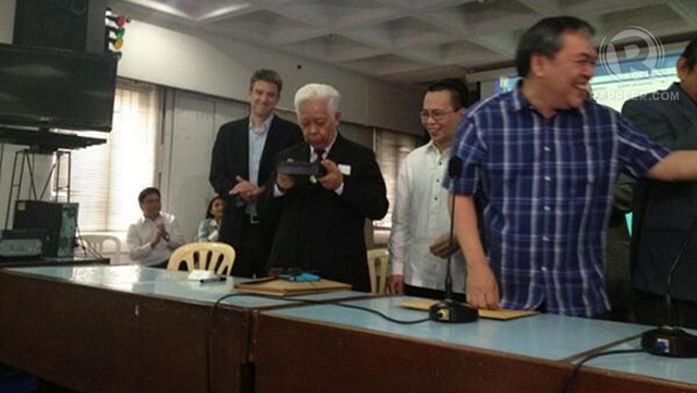 FOR GOOD LUCK? Comelec chair Sixto Brillantes Jr blows the sealed box containing the PCOS source code. Photo by Paterno Esmaquel II