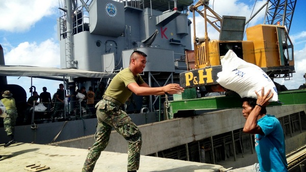 HUMANITARIAN MISSION. Volunteers and the Philippines load Sabah rice to BRP Sultan Kudarat. Photo by Karlos Manlupig