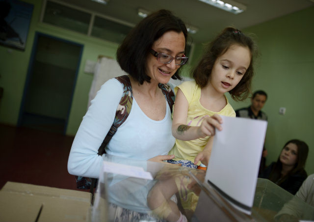 BULGARIA VOTES. A mother with her child vote at a polling station during EU elections in Sofia, Bulgaria on May 25, 2014. The European elections will form a new European Parliament, whose 751 members will help set laws in the European Union for five years to come. Photo by Vassil Donev/EPA