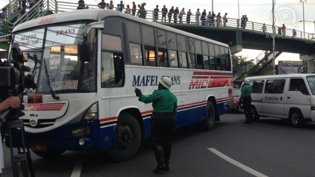 CAN'T PASS. A Manila traffic enforces prevents a bus Quezon city from entering Manila. Photo by Rappler/Bea Cupin