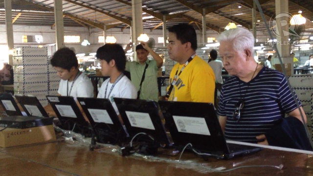 WAREHOUSE TOUR. Comelec chair Sixto Brillantes Jr (right) tours reporters in the Comelec warehouse in Cabuyao. Photo by Paterno Esmaquel II