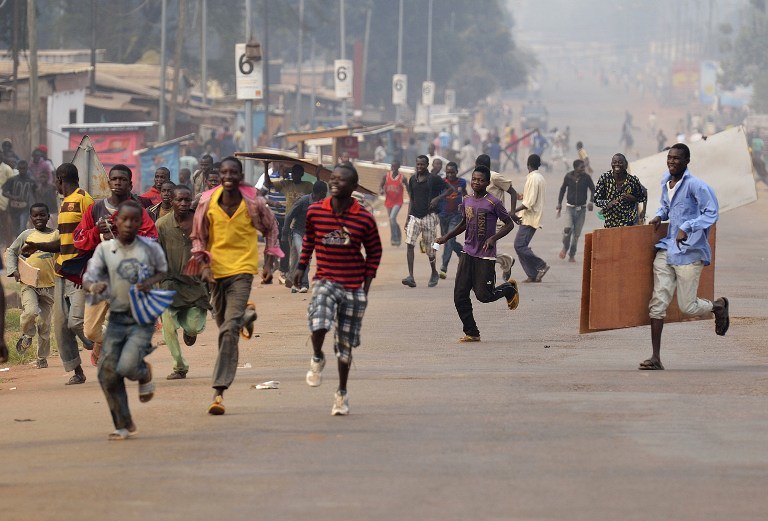 CHAOS IN BANGUI. Looters run for cover as they hear rifle shots near the 'Reconciliation crossroad' in Bangui, on January 11, 2014. Eric Feferberg/AFP