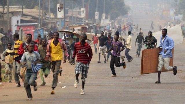 CHAOS. Looters run for cover as they hear rifle shots near the 'Reconciliation crossroad' in Bangui, on January 11, 2014. Eric Feferberg/AFP