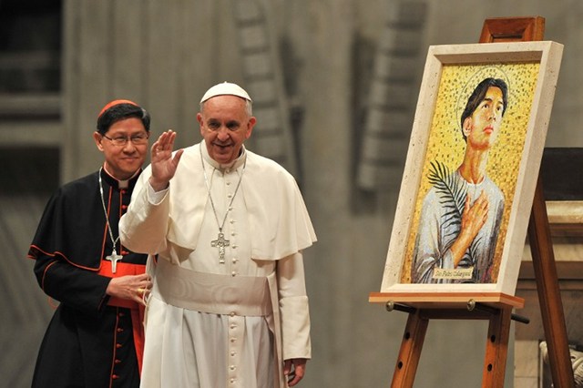 IMAGE UNVEILING. Pope Francis waves next to Filipino cardinal Luis Antonio Tagle during a ceremony to bless the new image of Holy Pedro Calungsod of Philippines at St Peter's basilica on November 21, 2013 at the Vatican.