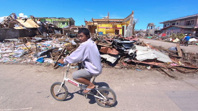 OBLITERATED TOWN. A resident rides his ramshackle bike through the debris in Cateel. Photo by Karlos Manlupig