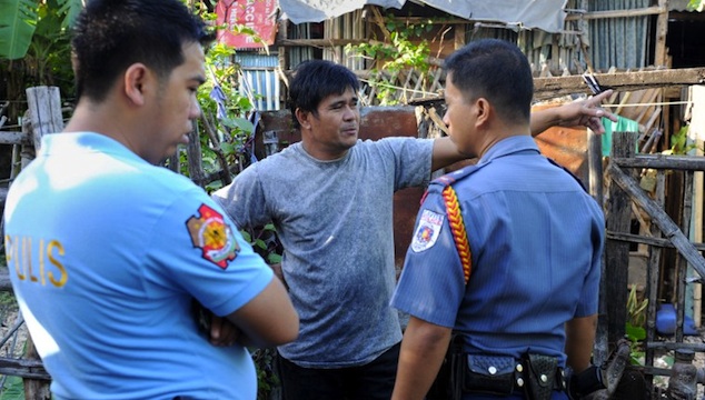 TRAGEDY IN CAVITE. Police officers talk to a relative of a victim following a shooting rampage in Kawit, about 40 kms (25 miles) south of Manila on January 4, 2013. AFP PHOTO / JAY DIRECTO