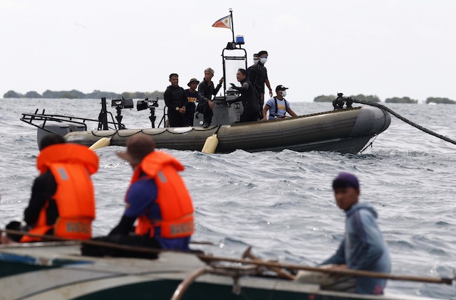 SEARCH & RETRIEVAL. Operatives of Philippine Navy on board a motorized rubber boat looking out toward waters off Cebu, 18 August 2013. Photo by EPA/ Dennis Sabangan