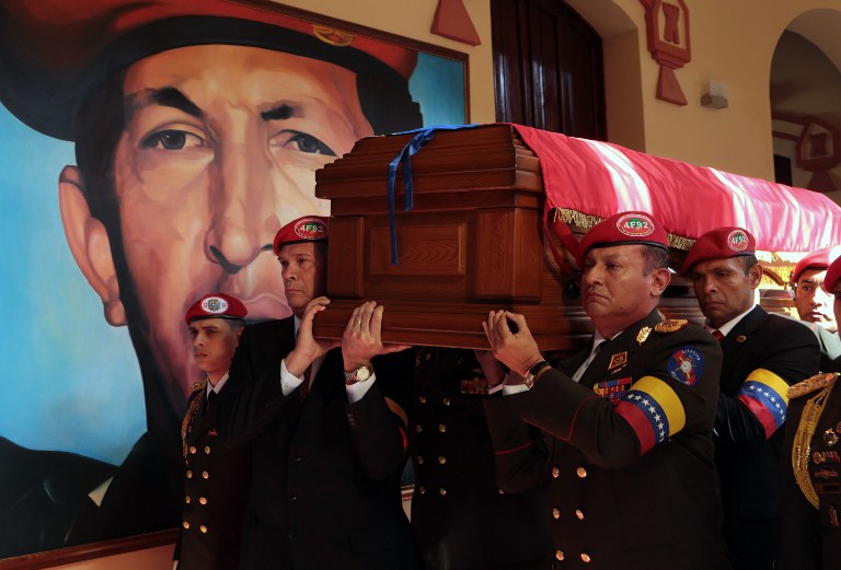 Handout picture released by the Venezuelan presidency showing members of the presidential Honor Guard carrying the coffin with the remains of late Venezuelan President Hugo Chavez as it arrives at a temporary resting place at the former "4 de Febrero" barracks -- a barracks-turned-museum that the former paratrooper had used as his headquarters during a failed 1992 coup attempt -- in Caracas, on March 15, 2013. AFP PHOTO/PRESIDENCIA/MARCELO GARCIA/HO