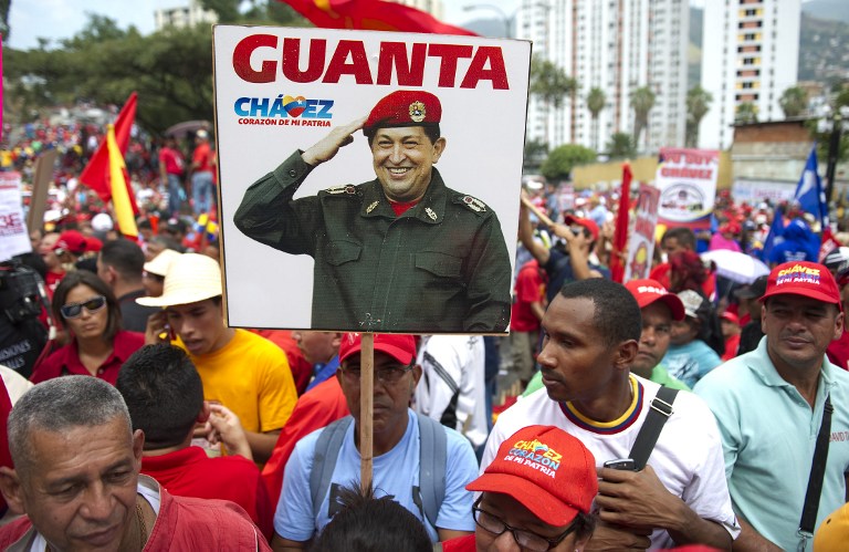 Supporters of Venezuelan President Hugo Chavez show a portrait of Venezuelan President Hugo Chavez in a rally to commemorate the 55th anniversary of the end of the dictatorship (1952-1958) of Marcos Perez Jimenez in Caracas on January 23, 2013. AFP PHOTO/JUAN BARRETO