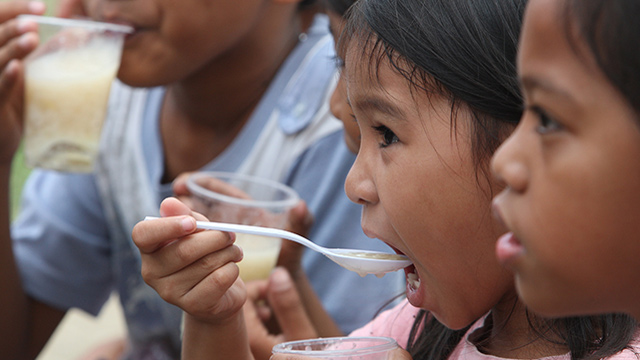 FEEDIGN THE MIND. Filipino children eat local porridge during a free feeding program for informal settlers in Quezon City, east of Manila, Philippines (18 March 2012). Photo by EPA/ROLEX DELA PENA