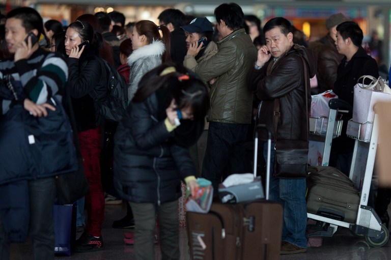 GOING HOME. Lunar New Year travelers queue at Beijing's international airport on February 6, 2013. AFP PHOTO / Ed Jones