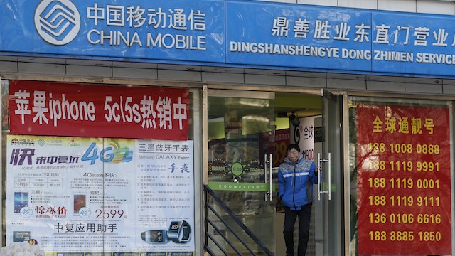 IPHONES SOLD HERE. A customer comes out of a commercial mobile phone store that sells iPhones and also operates as an authorized service center for China Mobile network subscribers, in Beijing, China, 18 December 2013. EPA/Rolex dela Pena