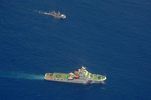 'GREAT EQUALIZER.' A Chinese coast guard ship (bottom) and a Philippine supply boat engage in a standoff on March 29, 2014. Both the Philippines and China cite international law in claiming the West Philippine Sea. Photo by Jay Directo/AFP