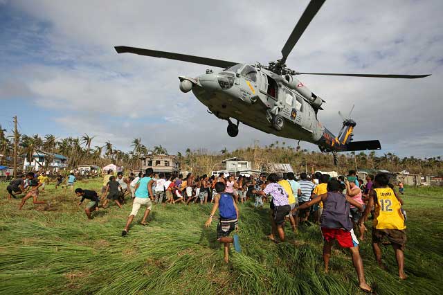 WELCOME. Filipino typhoon victims rush to get relief goods from a US Navy Sea Hawk helicopter in the super typhoon devastated town of Salcedo, Samar. Photo by Francis Malasig/EPA