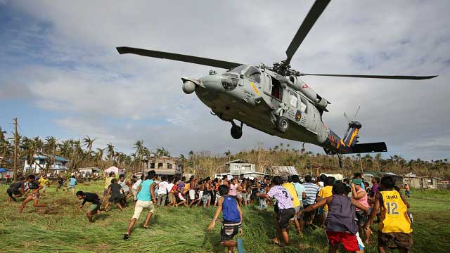 WELCOME RELIEF. Filipino typhoon victims rush to get relief goods from a US Navy Sea Hawk helicopter in the super typhoon devastated town of Salcedo, Samar. Photo by Francis Malasig/EPA