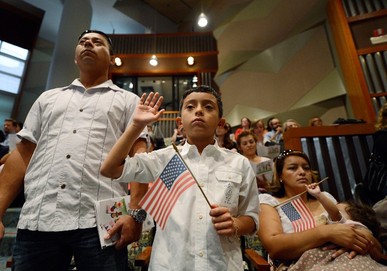 U.S. citizenship candidate Ricardo Barrera, 8, takes the oath of citizenship as his father Ricardo Barrera (L), mother Reina Barrera and his sister Ashley, 1, look on during a naturalization ceremony at the Los Angeles Central Library on September 19, 2012 in Los Angeles, California. Kevork Djansezian/Getty Images/AFP