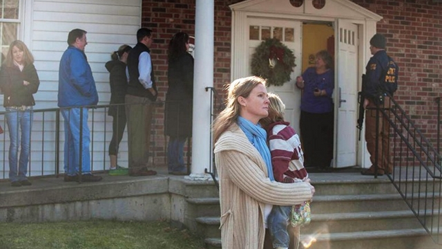 SCHOOL SHOOTING. A woman holds a child as people line up to enter the Newtown Methodist Church near the the scene of an elementary school shooting on Friday in Newtown, Connecticut. Photo by Douglas Healey/Getty Images/AFP