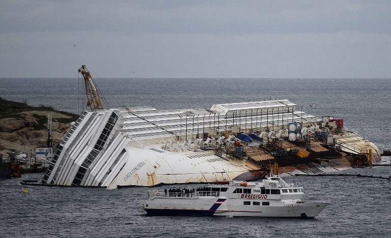 REMEMBERING THE VICTIMS. Relatives sail on January 13, 2013 by the Costa Concordia cruise ship keeled over off the Italian island of Giglio, for commemorations marking the first anniversary of the disaster. AFP PHOTO / ALBERTO PIZZOLI