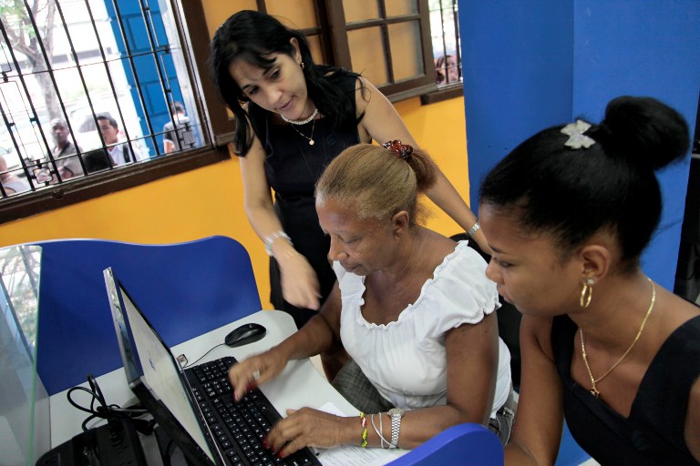 INTERNET IN CUBA. An employee of ETECSA (Cuban telecommunications company) helps a client at a cyber place in Havana on June 4, 2013. AFP