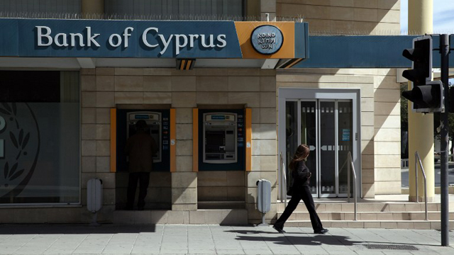 A man withdraws money from an ATM in the Cypriot capital of Nicosia on March 16, 2013. AFP PHOTO/YIANNIS KOUTOGLOU