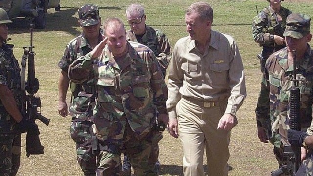 US pacific commander Admiral Dennis Blair (right in khaki uniform) accompanied by Lieutenant. Colonel David Maxwell (L) troops the line on his arrival at the Philippine Army 103rd Infantry Battalion headquarters in Tabiawan, Basilan island  15 April 2002.  Admiral Blair is in the southern Philippines to visit US special forces troops training Philippine soldiers to destroy the Abu Sayyaf Muslim extremistsallegedly llinked to Osama bin Laden's Al Qaeda network.  AFP  PHOTO / Conrado Maralit