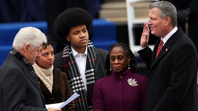 NEW MAYOR. New York City's 109th Mayor, Bill de Blasio(right), is sworn in by former President Bill Clinton(left) as his family watches, Chiara de Blasio (2nd from left) Dante de Blasio (center) and wife Chirlane McCray (2nd from right) at City Hall on January 1, 2014 in New York City. Photo by Spencer Platt/Getty Images/AFP