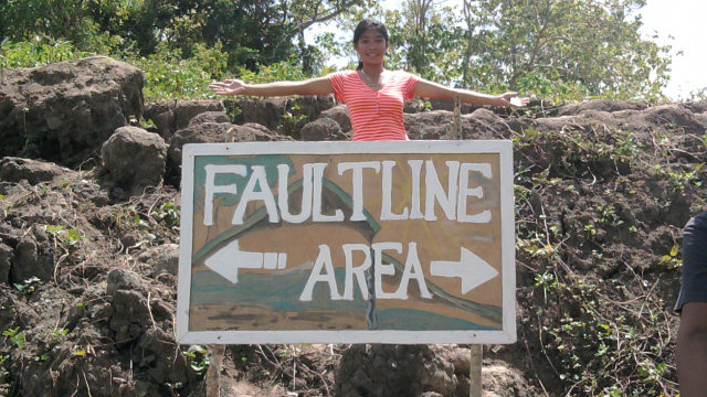 Deniece Alota stands beside the fault line in Bohol. Photo from Alota's Facebook