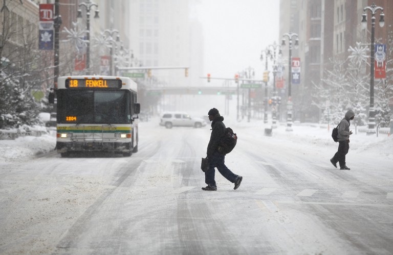 FREEZING DETROIT. Pedestrians cross Woodward Avenue as it snows as the area deals with record breaking freezing weather January 6, 2014 in Detroit, Michigan. Joshua Lott/Getty Images/AFP
