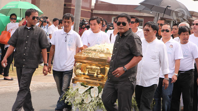 TO THE BURIAL SITE. Pall bearers -- among them, Manila Mayor Alfredo Lim -- carry it a short distance from inside a chapel to the burial grounds. Photo by Geric Cruz