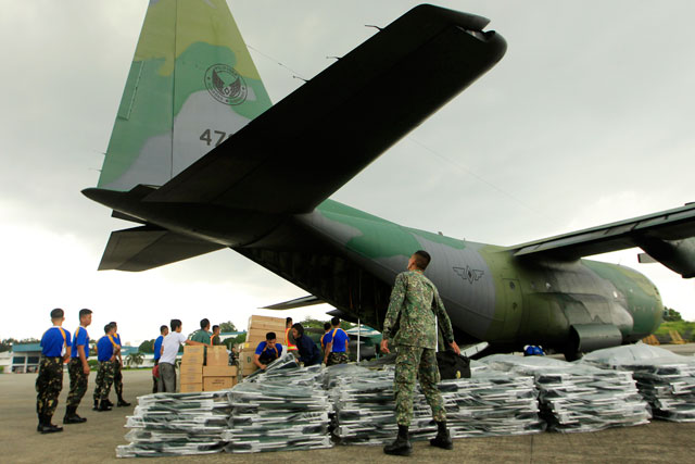 RELIEF. Soldiers load relief goods for earthquake victims in Central Visayas into a C-130 cargo military plane at Villamor Airbase in Pasay city. Photo by EPA/Francis Malasig